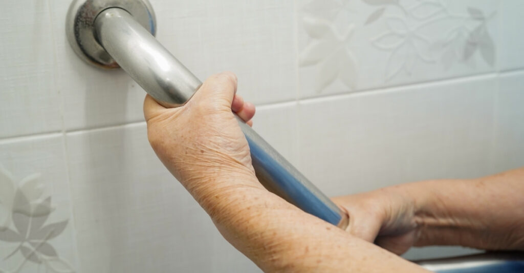 senior holding bathroom grab bar for safety