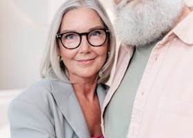 Close-up of a smiling senior woman wearing eyeglasses indoors.
